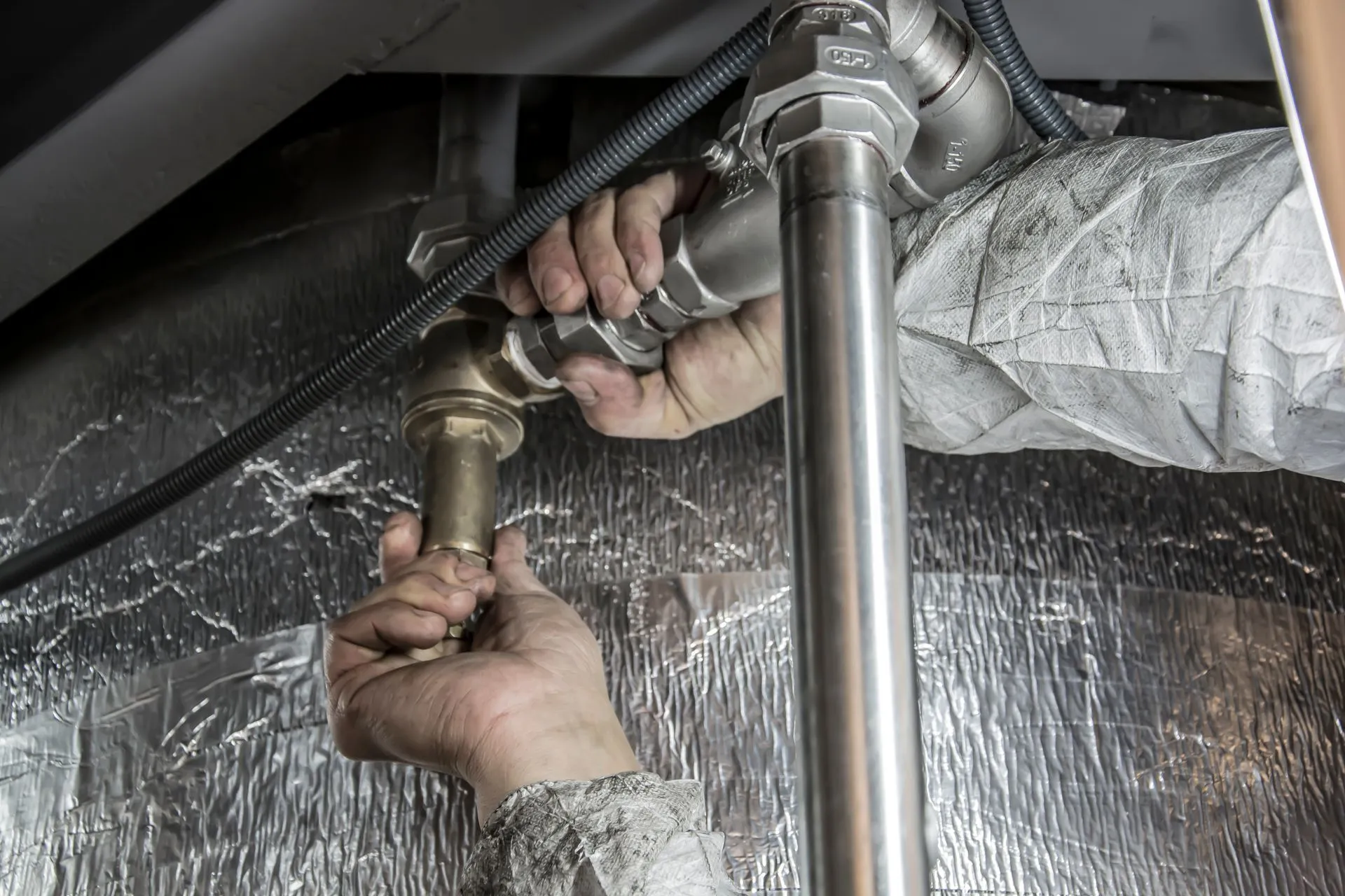 Close-up of hands tightening a pipe connection